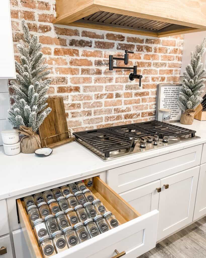 White Kitchen With Brick Wall Behind Stove 819x1024 