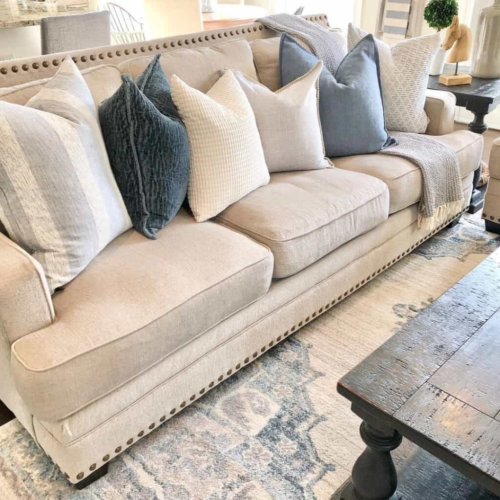 https://www.soulandlane.com/wp-content/uploads/2022/11/Cushioned-Off-White-Couch-with-Blue-and-White-Throw-Pillows-1024x1024.jpg